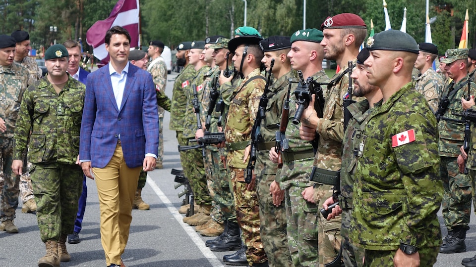 Justin Trudeau inspecte les troupes de l'OTAN dont les soldats sont en rang.