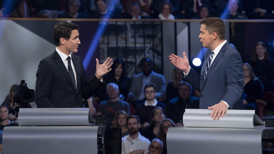 Justin Trudeau et Andrew Scheer se font face et s'adressent l'un à l'autre sur le plateau du débat en anglais.