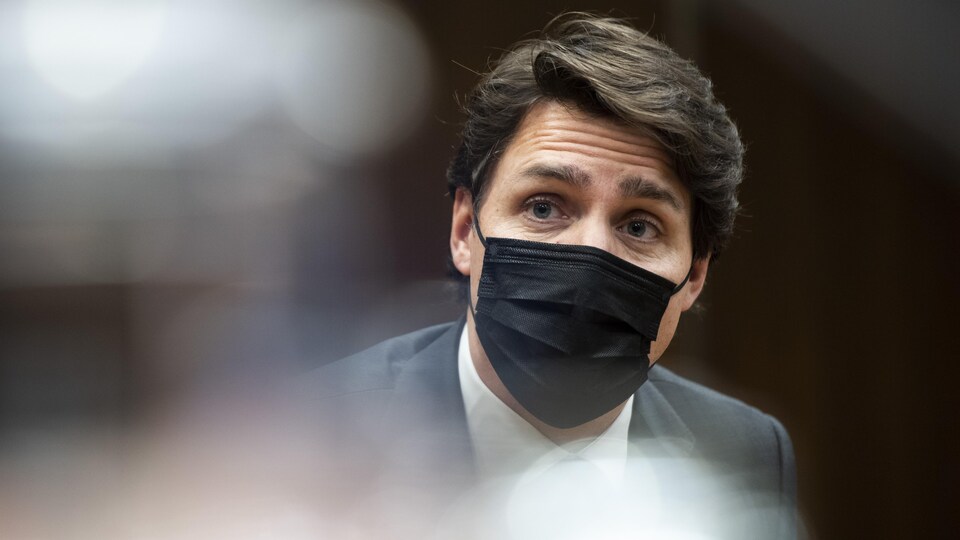 Gros plan de Justin Trudeau portant un masque noir.