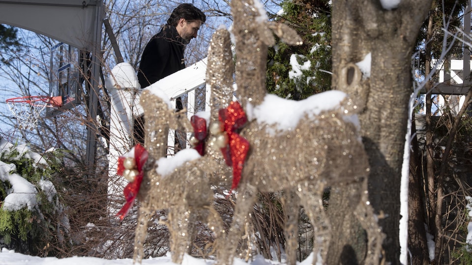 Justin Trudeau monte des marches, derrières des décorations de Noël.