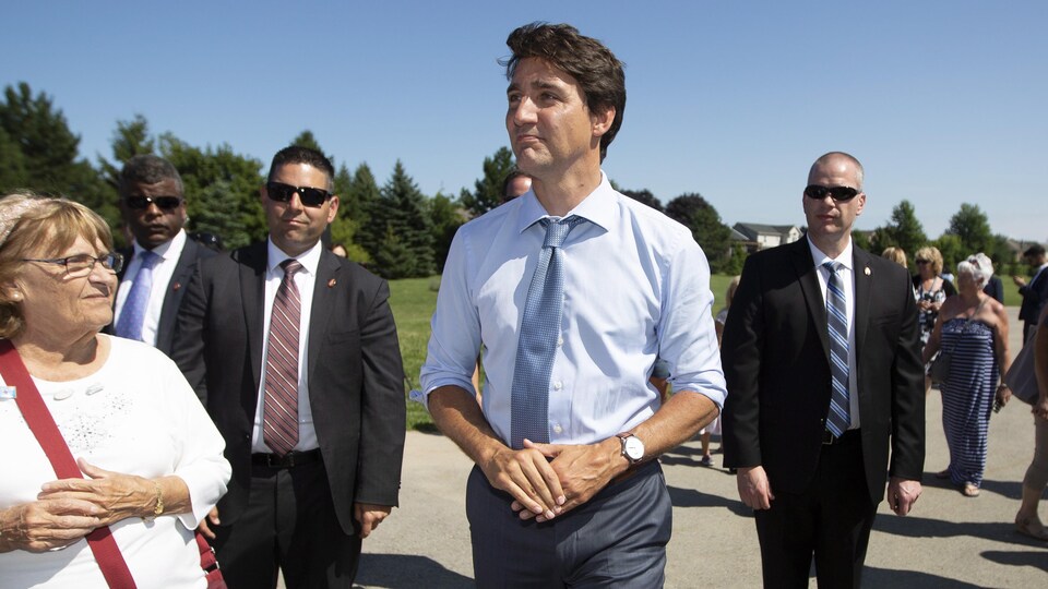 Justin Trudeau entouré de gardes de sécurité.