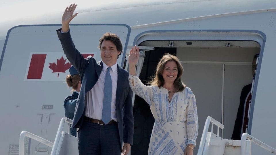 Justin Trudeau et Sophie Grégoire Trudeau sortant d'un avion, saluant la foule. 
