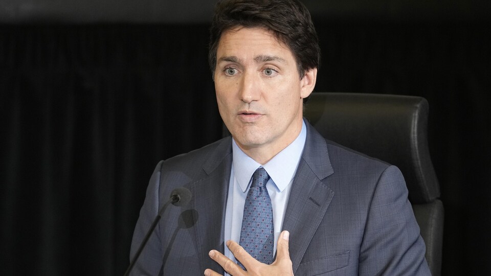 Justin Trudeau, assis derrière un micro, témoigne. 