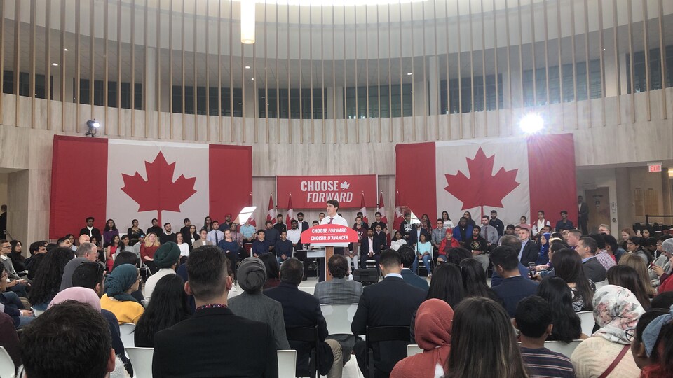 Justin Trudeau s'adresse à la foule, essentiellement des étudiants, réunis dans une grande pièce aux plafonds hauts.