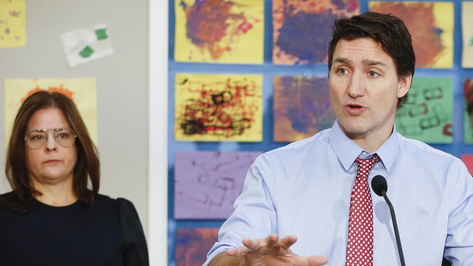 Justin Trudeau parle au micro, aux côtés de la première ministre manitobaine, Heather Stefanson, dans une garderie de Winnipeg.