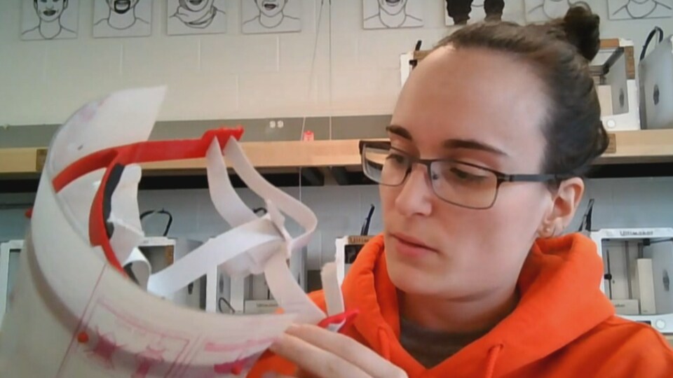 Justine Boudreau tient une visière de plastique.