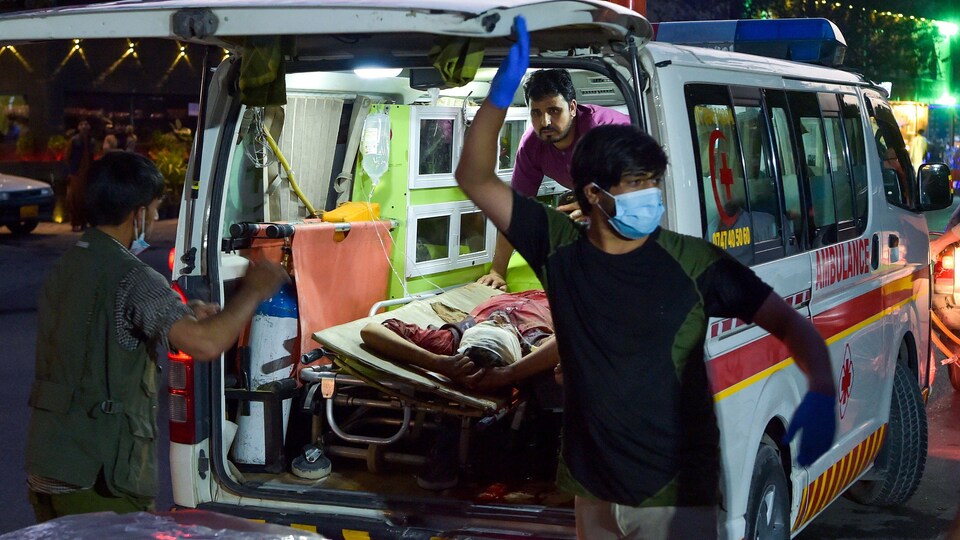 Des ambulanciers transportent un blessé.