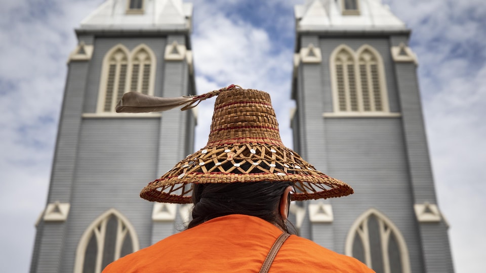 Un membre de la Nation Squamish, en Colombie-Britannique, vue de dos devant une église.