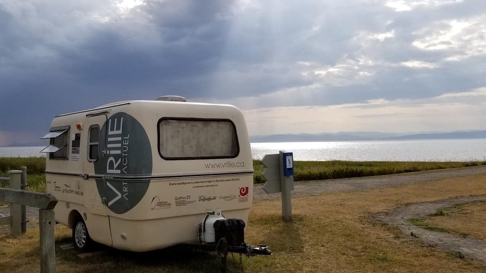 Roulotte Vrille Art Actuel stationnée le long du fleuve Saint-Laurent avec vue sur la rive opposée