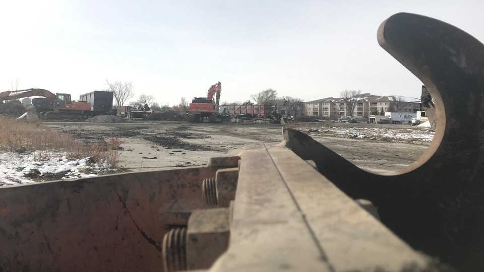 Des engins de chantier dans un terrain vague.