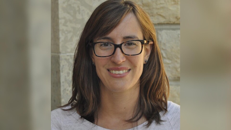 Une photo de la Dre Karen Leis devant un mur de brique.