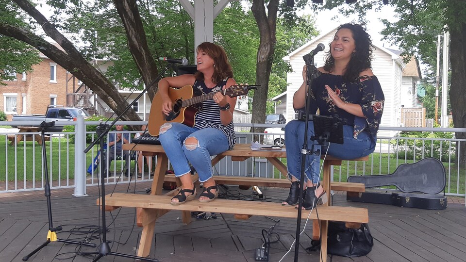 Une guitariste et une chanteuse sous un gazebo