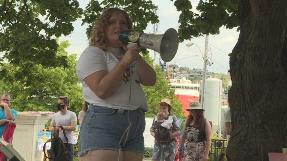 Kat McLaughlin parle dans un micro lors de la manifestation. 