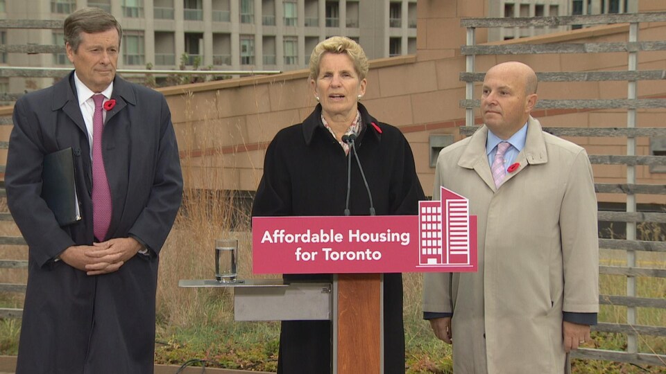 De gauche à droite, le maire John Tory, la première ministre de l'Ontario Kathleen Wynne et le ministre du Logement Peter Milczyn