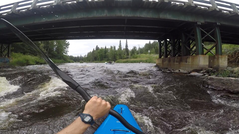 Une personne en kayak sur une rivière.