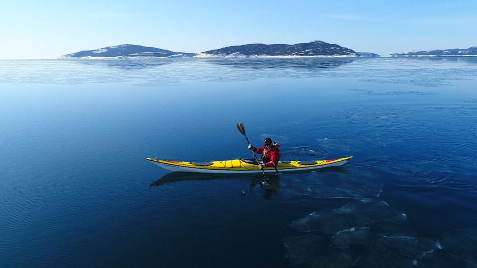 Un kayakiste sur la mer l'hiver.