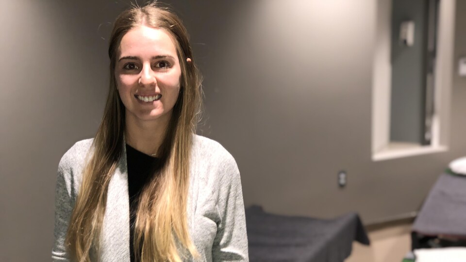 Kayla Bélanger devant des lits de camps.