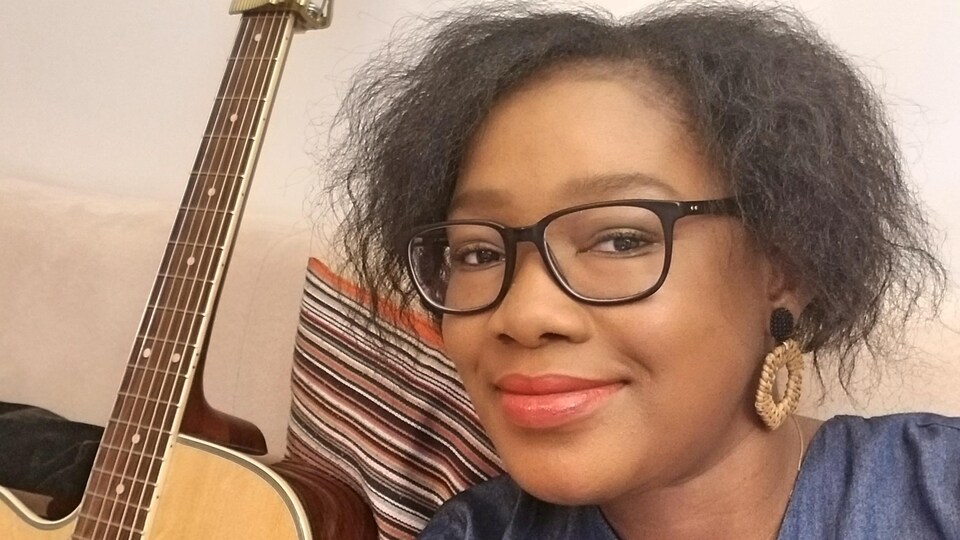 L'auteure-compositrice-interprète Kelly Bado. À sa droite, il y a sa guitare.