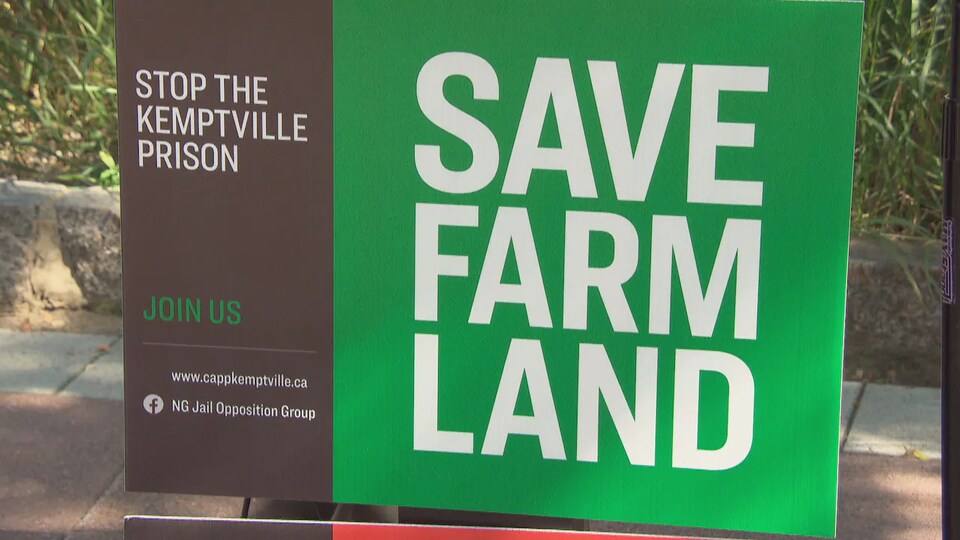 Un panneau sur lequel est écrit : "Sauvez les terres agricoles".