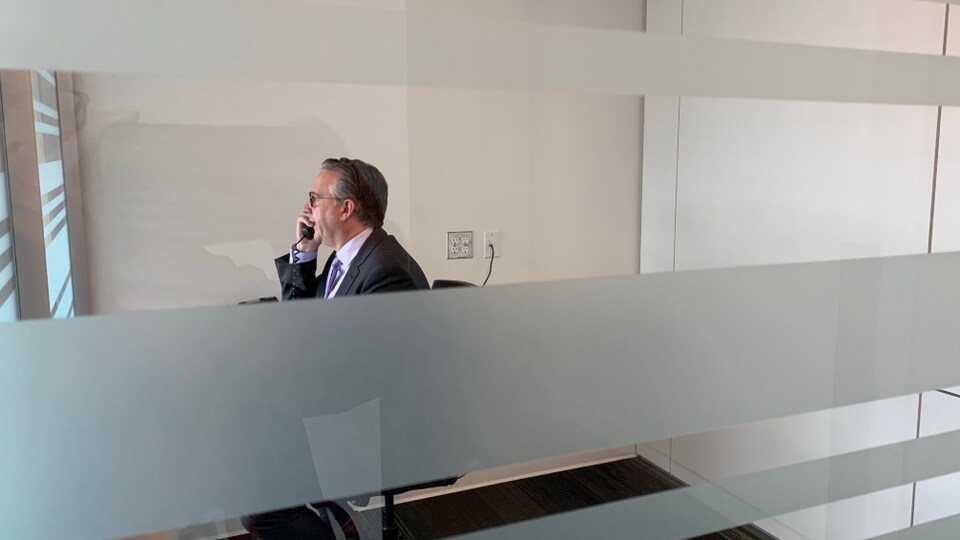 Un homme au téléphone, dans un bureau.