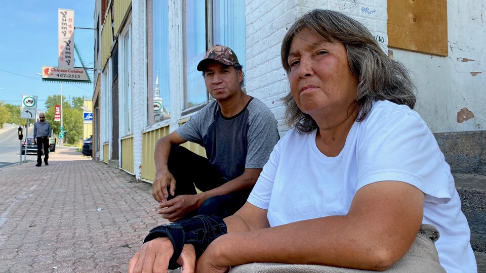 Deux Autochtones sont assis sur des marches dans le centre-ville de Kenora.