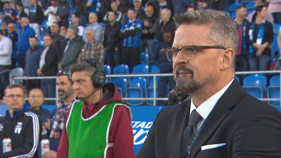 Kevin Gilmore, en bordure du terrain, observe un match.