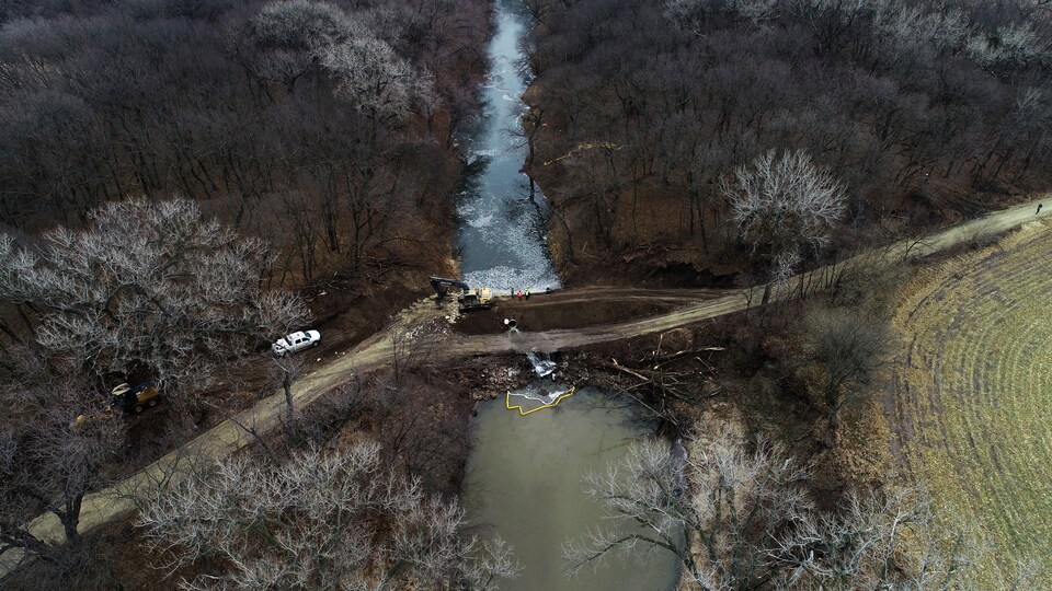 Photo prise par un drone le 9 décembre 2022. On voit un cours d'eau entouré d'arbre et des travailleurs qui s'affairent à faire le nettoyage.