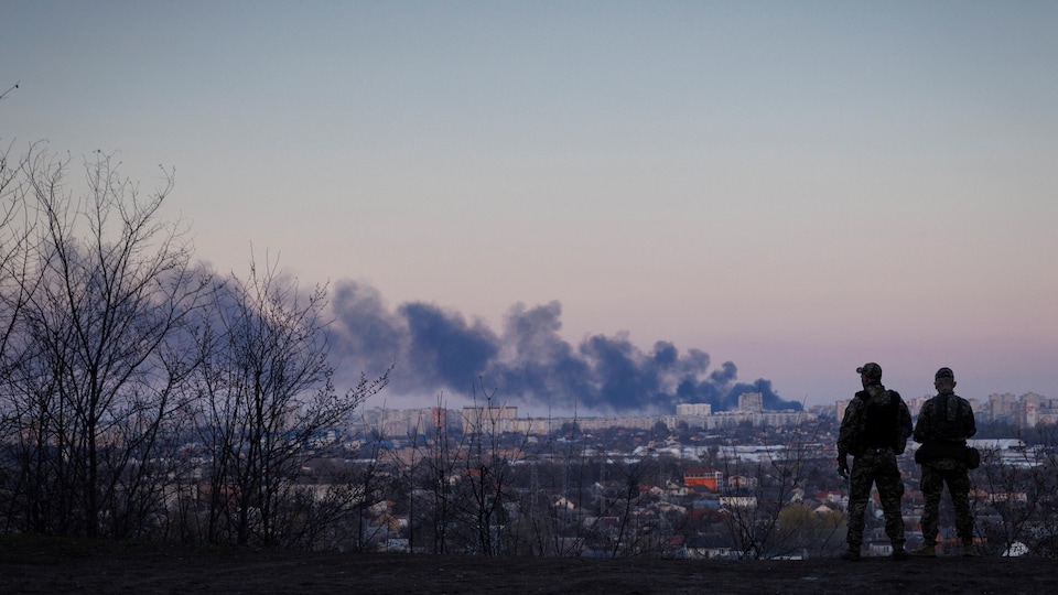 Soldiers watch a column of smoke in Kharkiv, Ukraine.
