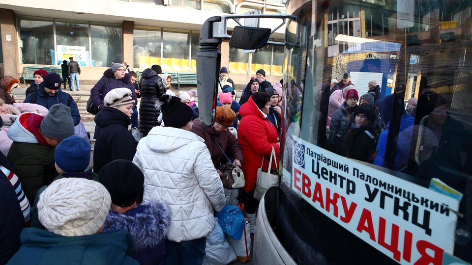 Des Ukrainiens attendent de monter dans un autobus pour quitter Kherson.