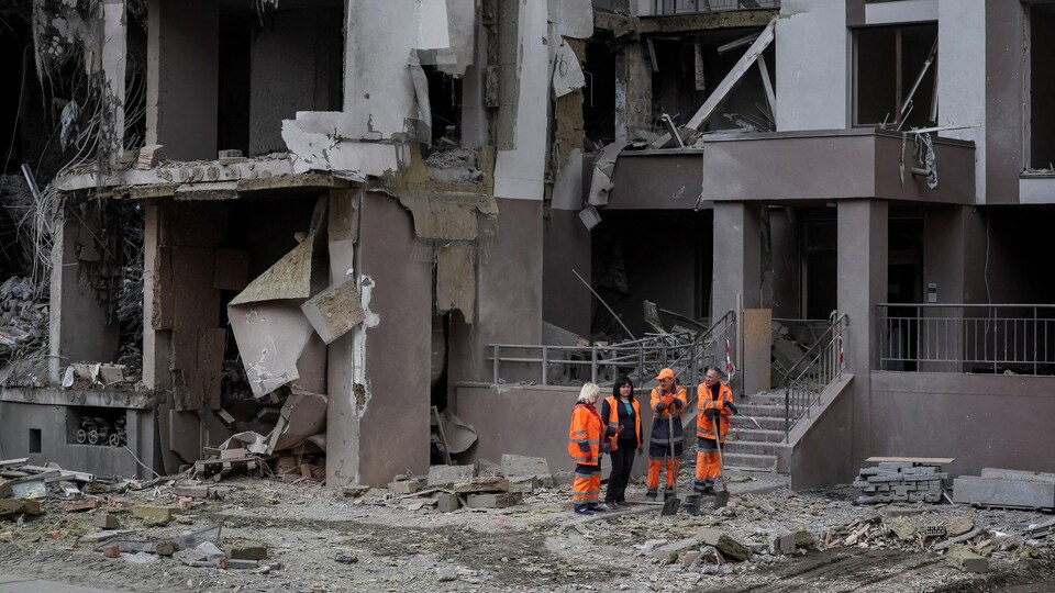 Rescue workers stood near a damaged building.
