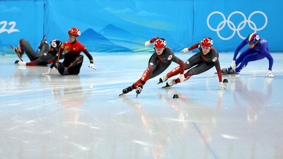 Deux patineuses chutent dans un virage.