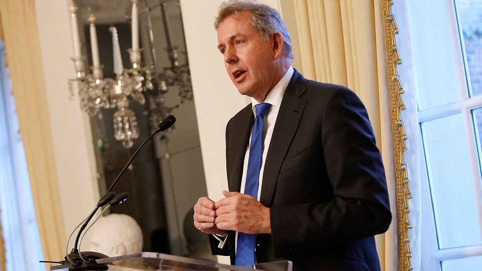 Kim Darroch devant un lutrin.