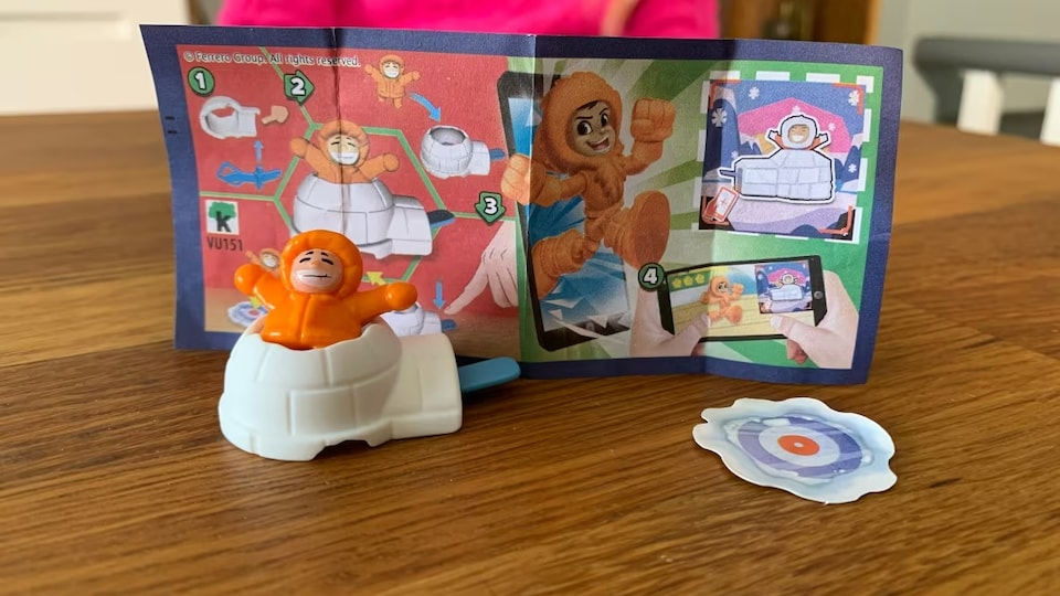 Le jouet est posé sur une table avec le dépliant qui l'accompagne.
