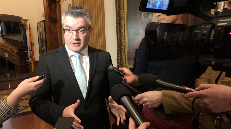 Kris Austin devant des représentants des médias.