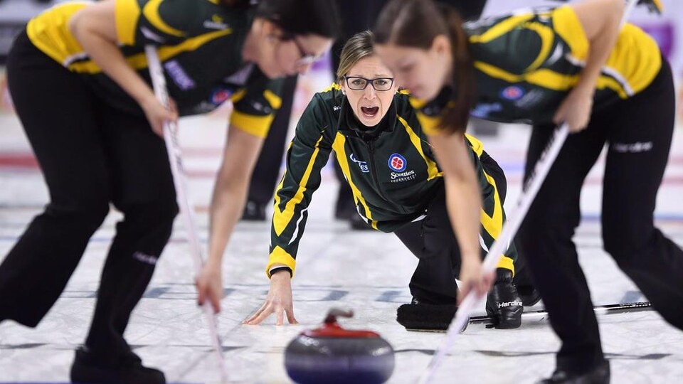 Trois joueuses de curling.