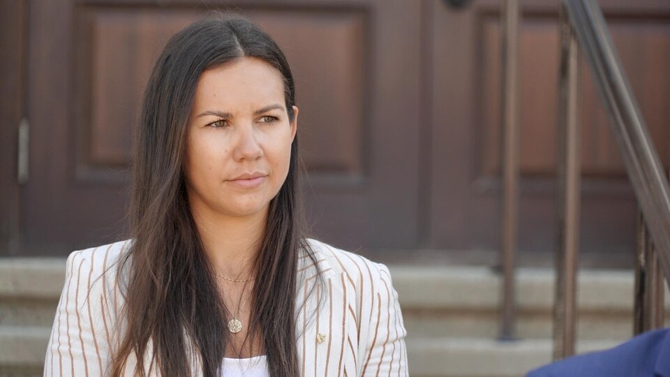 La politicienne porte un veston. Son regard est tourné vers le chef du Bloc Québécois.