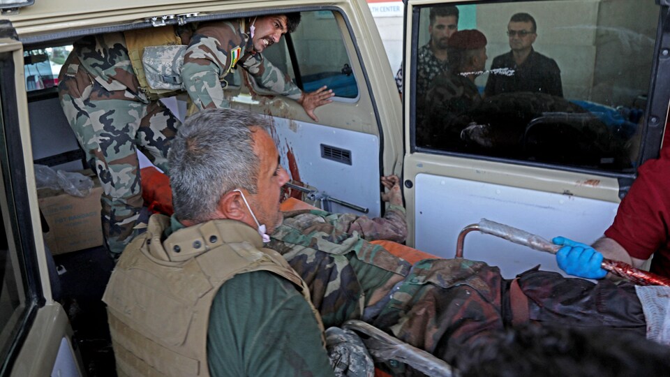 Des peshmergas du Kurdistan irakien sortent l'un des leurs d'une ambulance après une frappe iranienne dans la région d'Altun Kupri.