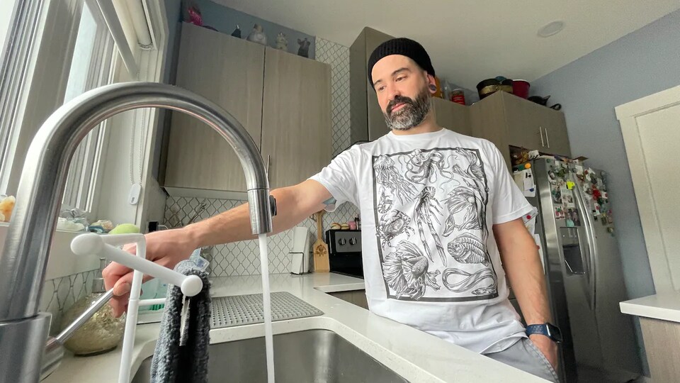 La photo de Kurtis Anderson dans sa cuisine devant le robinet.