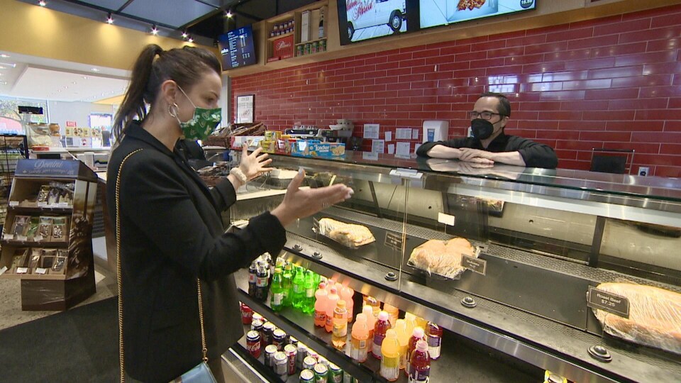 Natalia Kusendova salue le propriétaire de Palma Pasta devant son comptoir de sandwichs.