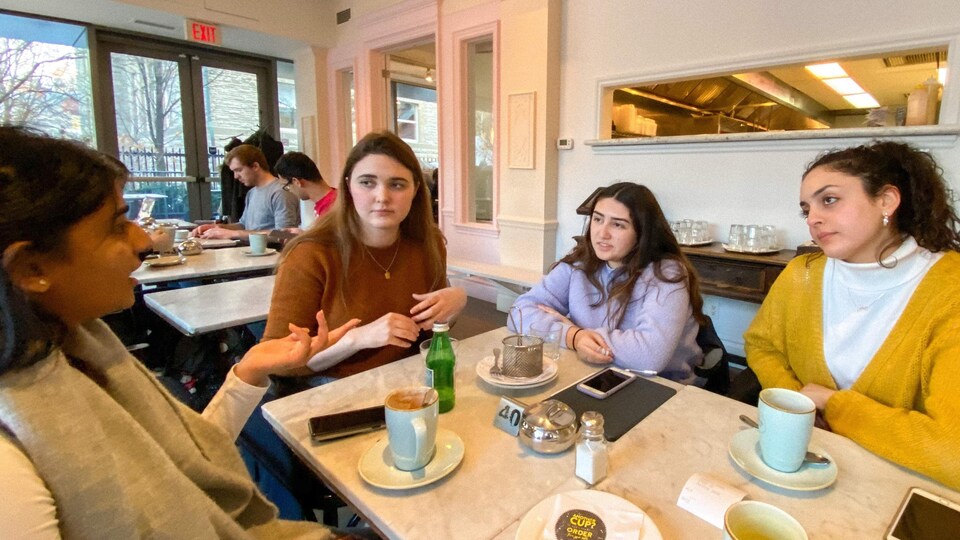 Un groupe de jeunes femmes réunies autour d'une table de café.