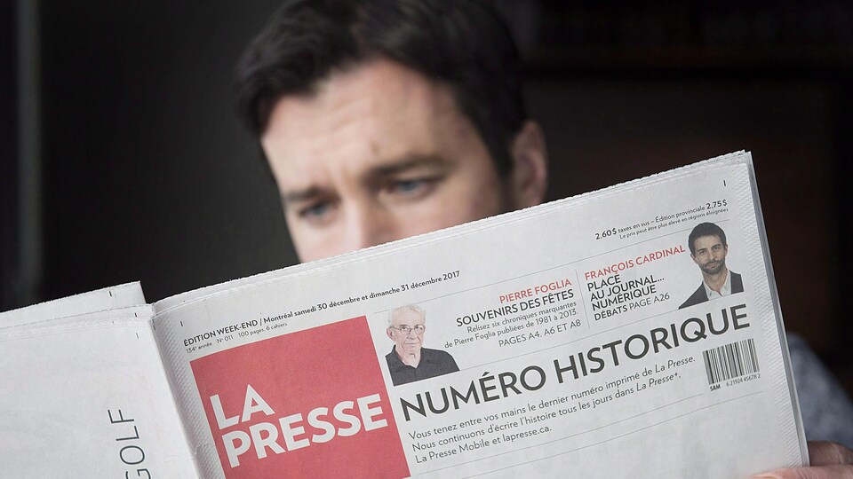 Un homme lit la dernière édition imprimée du journal « La Presse » dans un café de Vaudreuil-Dorion, à l'ouest de Montréal.
