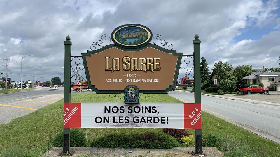 Une banderole qui indique : « Nos soins, on les garde! » est enroulée sur la marquise de la Ville de La Sarre.