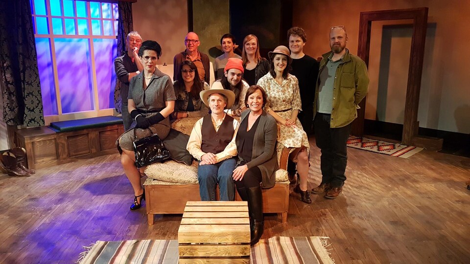 Les membres d'une production de la troupe du jour sur la scène pour une photo de groupe