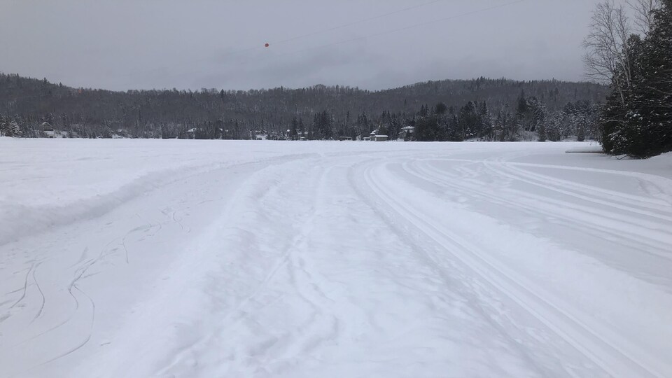 L'anneau de glace et un sentier tracé dans la neige pour les skieurs sur le lac Clair.