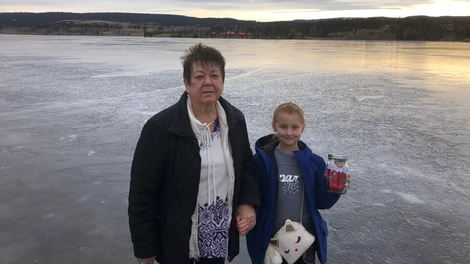 Une femme et une fille devant un lac gelé.