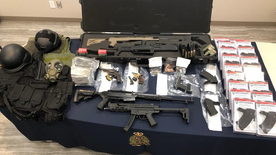 Plusieurs armes à feu sur une table.