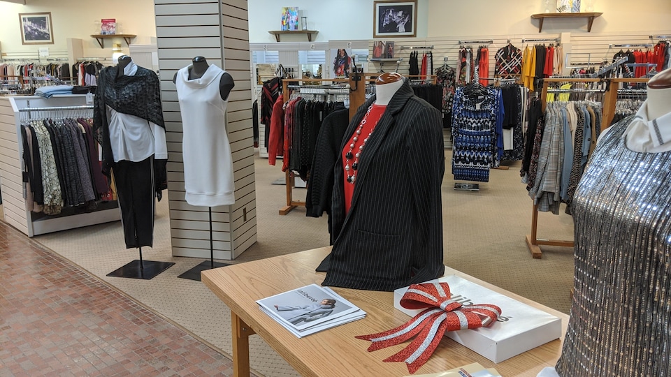 Des vêtements sur une table portés par des mannequins en tissu.