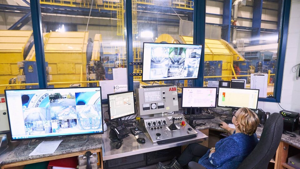 Une personne surveille des écrans dans une mine.