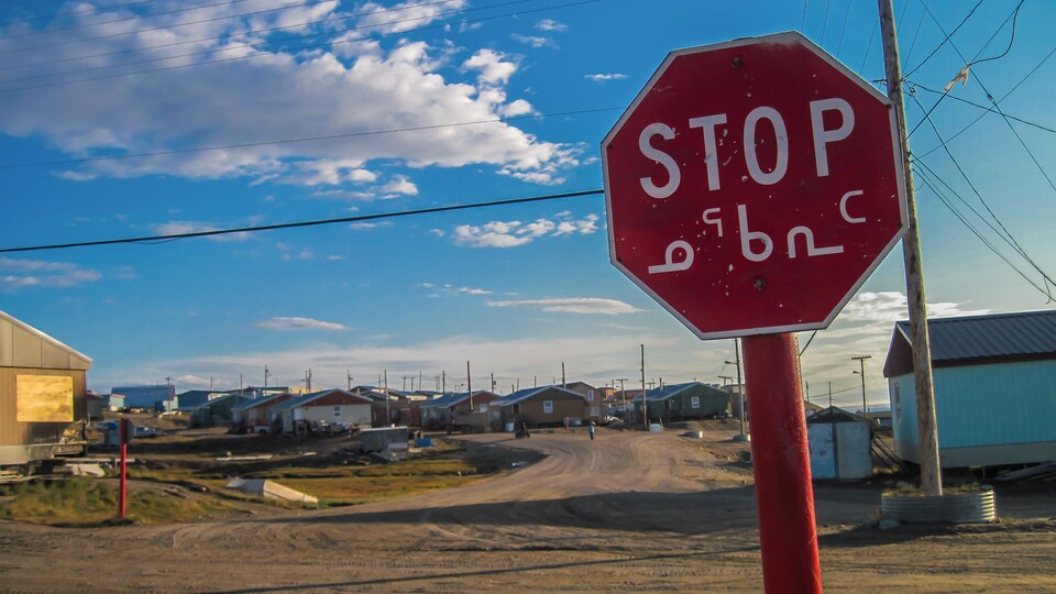 Un panneau « arrêt » traduit en anglais et en inuktitut dans un village de l'Arctique canadien.