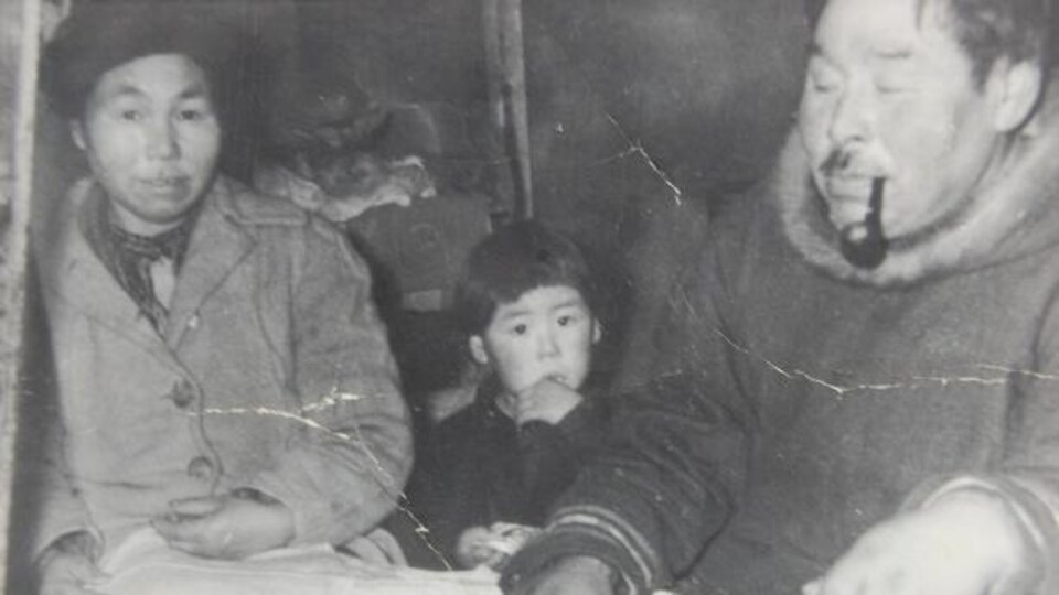 Un garçon inuit en compagnie de ses parents sur une vieille photo d'archive